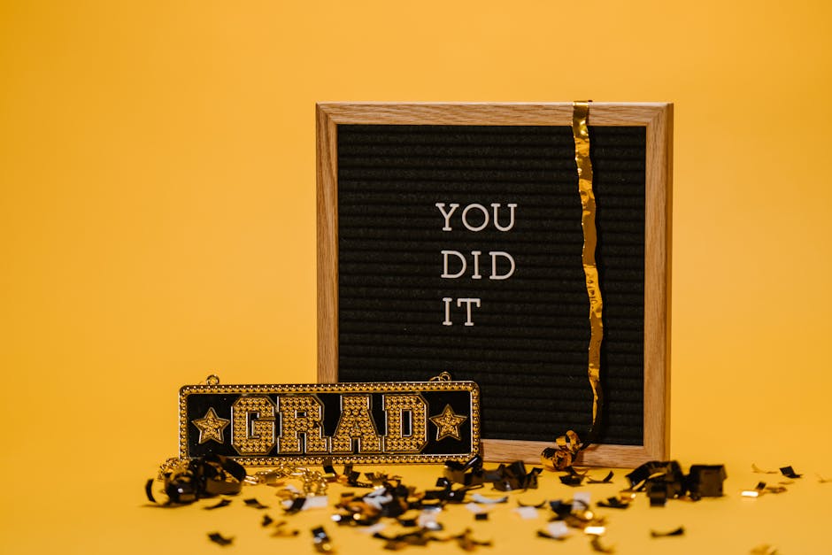 A graduation celebration with a letter board and confetti on a vibrant yellow background.