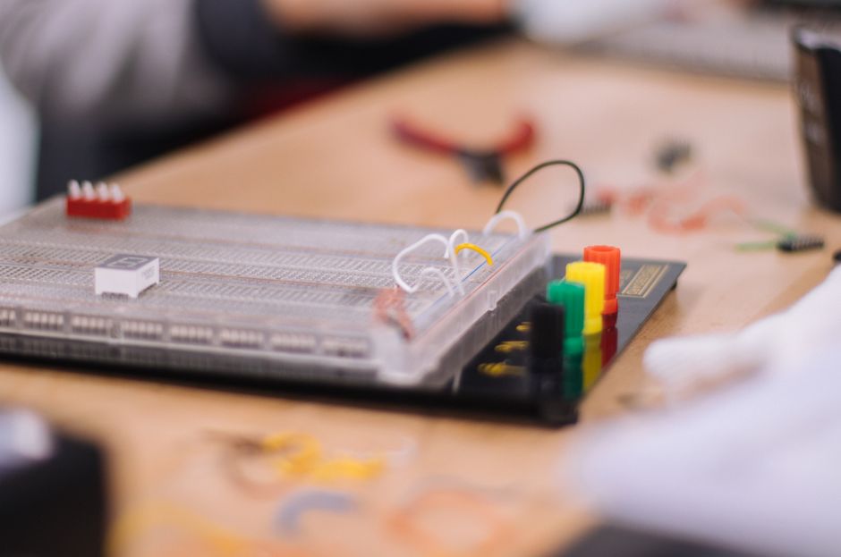Detailed view of an electronic breadboard setup on a workbench, ideal for STEM education.