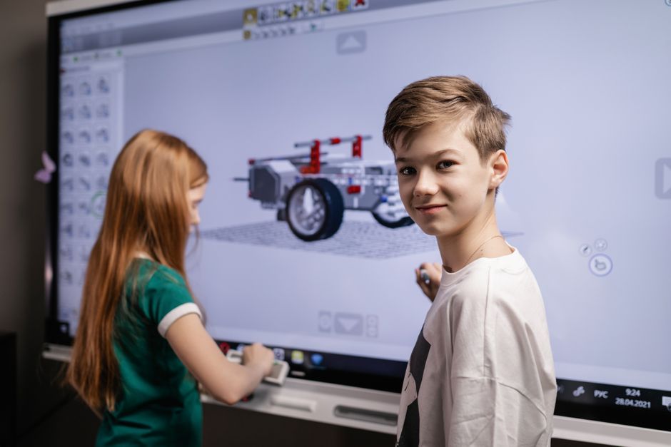Kids interacting with a touchscreen, embracing technology education.