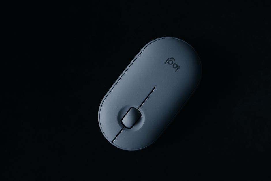 Sleek, modern wireless mouse displayed on a black background in an artistic flat lay.